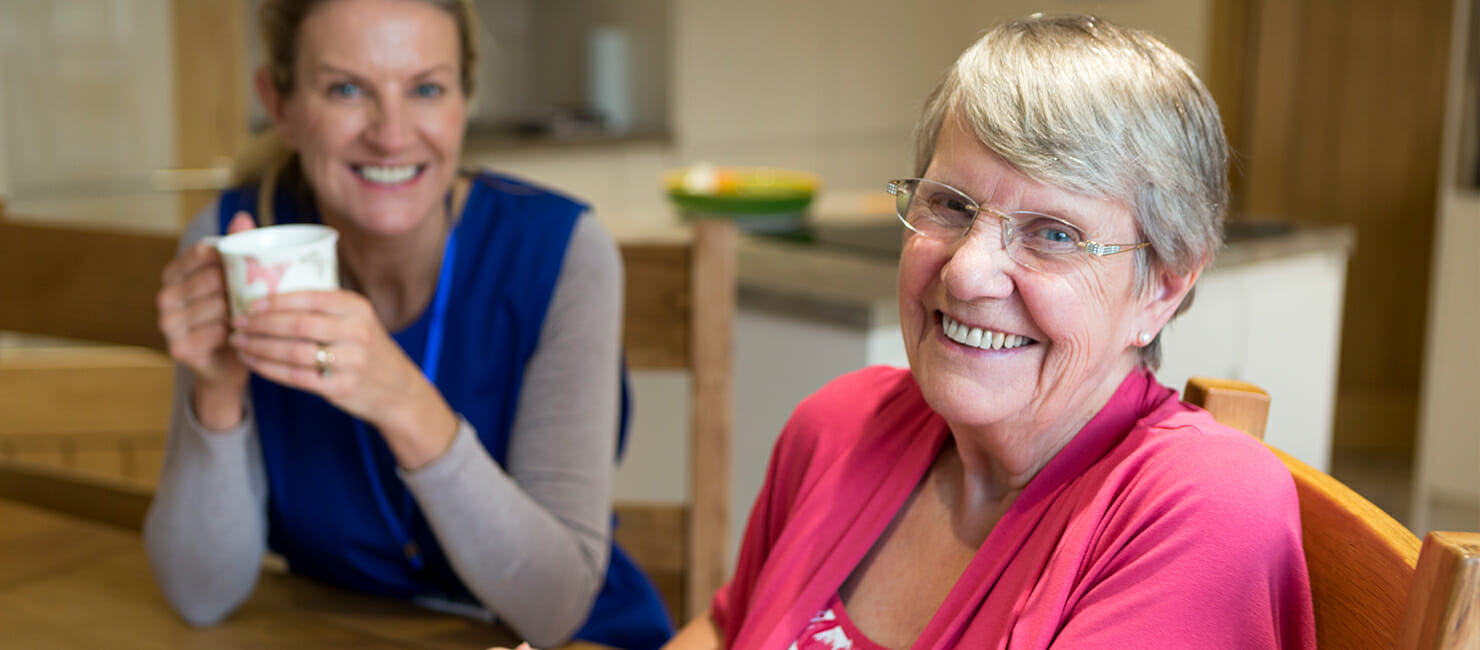 Older woman sitting with care aid