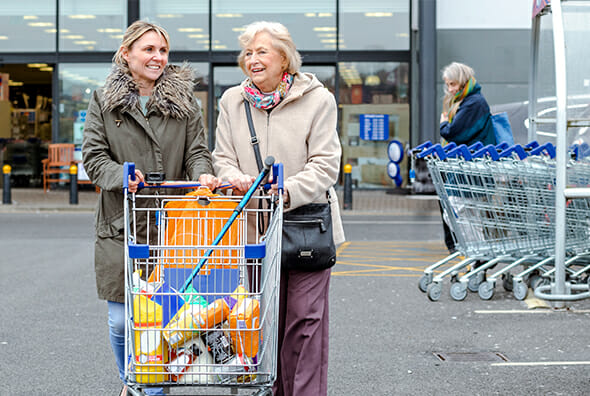 Young woman helping an elderly woman with groceries